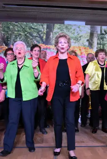 מקהלה של גברים ונשים הנשים לבושות ז'קטים בצבעים שונים