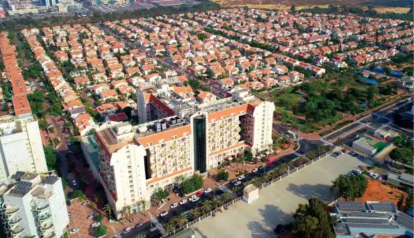 צילום מלמעלה של אחוזת ראשונים והסביבה המכילה הרבה מאוד בתים קטנים עם גגות רעפים