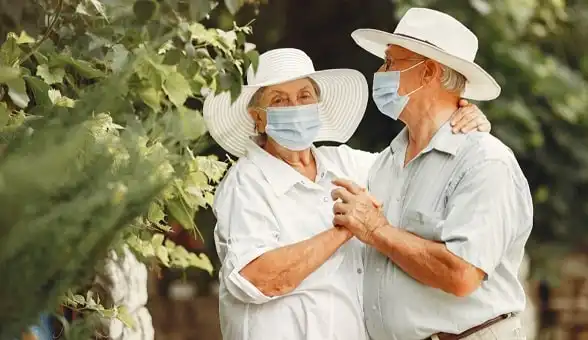 גבר ואישה עם כובעים לבנים בריקוד רומנטי ליד עץ ירוק