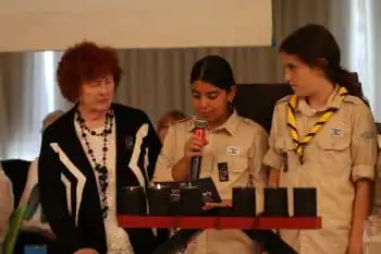 בנות צופים עם דיירת בטקס יום השואה באחוזת ראשונים