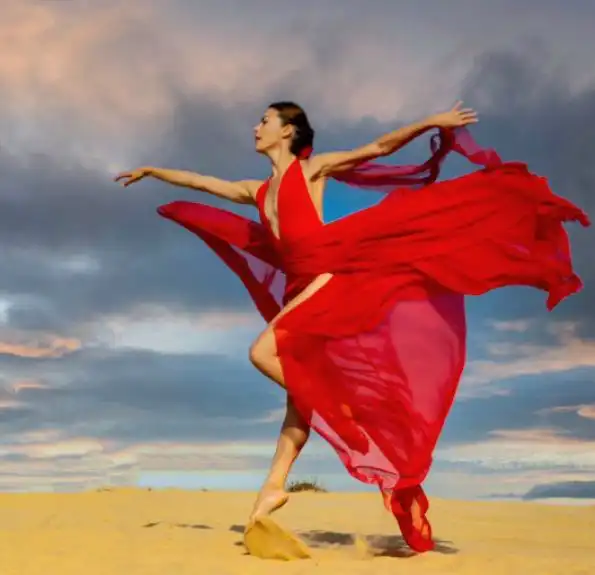 צילום של גלעד הראל - אישה בחוף הים עם שמלה אדומה