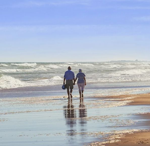 זוג מבוגר צועד יד ביד בים - אחוזות רובינשטיין