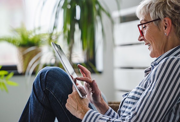 אישה כבת 70 מסתכלת בלפטופ